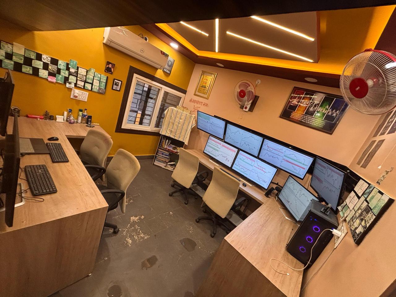Trading room desks with chart screens and learning wall